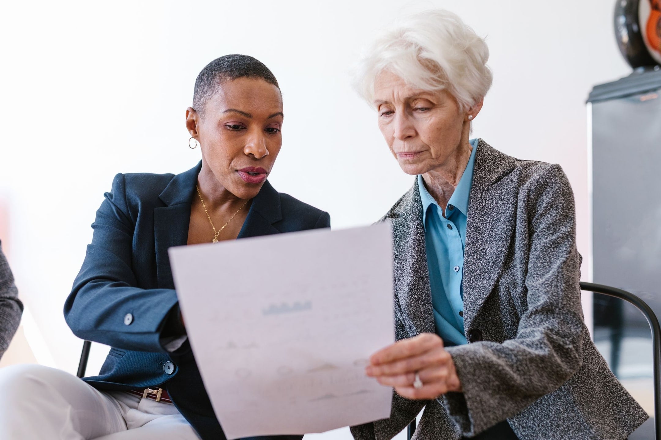 A senior colleague reviews a document with a younger professional.